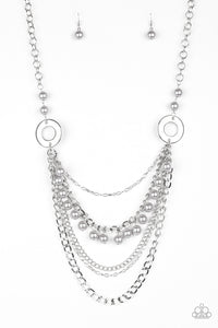 Dramatic silver hoops give way to layers of mismatched silver chains. Pearly silver beads trickle from the second chain, creating a flirty fringe across the chest. Features an adjustable clasp closure. Sold as one individual necklace. Includes one pair of matching earrings.