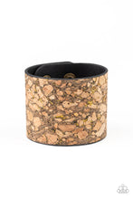 Load image into Gallery viewer, Pieces of cork have been plastered across the front of a black leather band, creating an earthy look around the wrist. Specks of glittery brass accents are sprinkled across the front for a flashy finish. Features an adjustable snap closure.  Sold as one individual bracelet.
