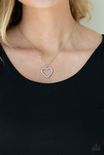 Load image into Gallery viewer, Encrusted in sparkly white rhinestones, an airy silver heart frame swings from a dainty silver chain below the collar for a romantic look. Features an adjustable clasp closure.  Sold as one individual necklace. Includes one pair of matching earrings.
