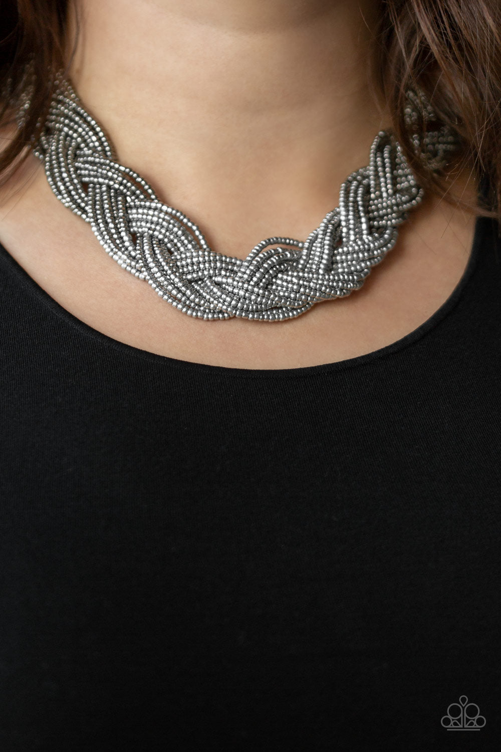 Strands of gunmetal seed beads create an indigenous braid below the collar. The gunmetal seed beads gradually morph into metallic silver beads at the center for a chic contrasting look. Features an adjustable clasp closure. Sold as one individual necklace. Includes one pair of matching earrings.