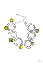 Load image into Gallery viewer, Bits of iridescent green shell swing from the bottoms of mismatched silver hoops around the wrist for a summery look. Features an adjustable clasp closure.
