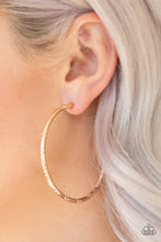 Load image into Gallery viewer, Etched in ribbons of diamond-cut shimmer, a shiny gold hoop curls around the ear for a classic look. Earring attaches to a standard post fitting. Hoop measures 2 1/4&quot; in diameter. Sold as one pair of hoop earrings.
