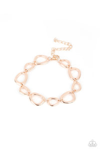 An array of irregular shaped rose gold rings link together and make their way around the wrist for a simple yet stylish avant-garde fashion. Features an adjustable clasp closure.