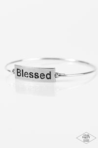 Engraved with the inspiring word "Blessed", a shimmery silver plate attaches to a skinny silver bar, creating a dainty bangle.  Sold as one individual bracelet.