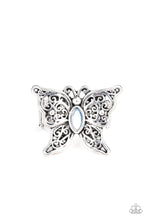 Load image into Gallery viewer, Lacy silver wings bloom from an opalescent blue cat&#39;s eye center, coalescing into a whimsical butterfly atop the finger. Features a stretchy band for a flexible fit. Sold as one individual ring.
