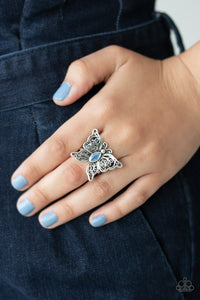 Lacy silver wings bloom from an opalescent blue cat's eye center, coalescing into a whimsical butterfly atop the finger. Features a stretchy band for a flexible fit. Sold as one individual ring.