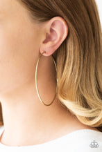 Load image into Gallery viewer, A skinny ribbon of brass curls into a bold hoop for a dramatic look. Earring attaches to a standard post fitting. Hoop measures 3” in diameter. Sold as one pair of hoop earrings.
