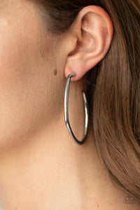 Brushed in a high sheen finish, a glistening gunmetal bar bends and curves into an asymmetrical hoop for a gritty finish. Earring attaches to a standard post fitting. Hoop measures approximately 1 3/4" in diameter. Sold as one pair of hoop earrings.