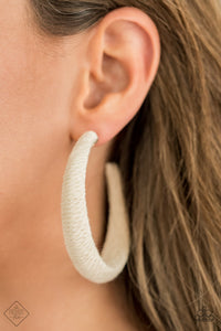 Earthy white twine-like cording is wrapped around a thick hoop, creating a colorful rustic display. Earring attaches to a standard post fitting. Hoop measures approximately 2 1/4" in diameter.  Sold as one pair of hoop earrings.