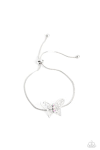 A deceptively simple silver butterfly charm glides along a silver snake chain for a whimsical flair along the wrist. Dainty, iridescent rhinestones encrust along the butterfly's body, creating an understated shimmer, while intricate, airy wings fold out from the sparkle, adding a 3D effect to the design. Features an adjustable sliding knot closure. Due to its prismatic palette, color may vary.  Sold as one individual bracelet.