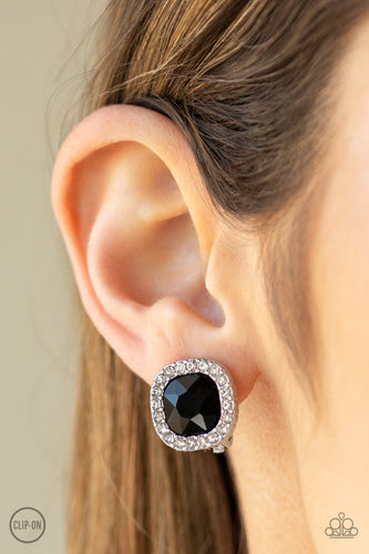 A border of glassy white rhinestones spins around a black gem center for a refined flair. Earring attaches to a standard clip-on fitting.  Sold as one pair of clip-on earrings.