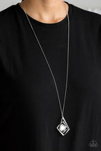 Load image into Gallery viewer, Dotted with glassy white rhinestones, antiqued silver bars twist and coil around a pentagonal white gem. The abstract pendant swings from the bottom of a lengthened silver chain for a modern look. Features an adjustable clasp closure.  Sold as one individual necklace. Includes one pair of matching earrings.

