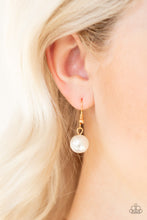 Load image into Gallery viewer, White pearl hanging from a gold fish hook earring.
