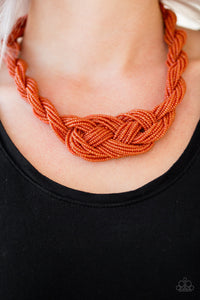 Countless strands of orange seed beads are twisted and knotted together to create an unforgettable statement piece. Features an adjustable clasp closure.  Sold as one individual necklace. Includes one pair of matching earrings.