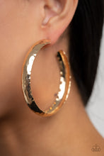 Load image into Gallery viewer, A thick piece of gold has been heavily hammered and delicately curved into a dramatically handcrafted hoop. Earring attaches to a standard post fitting. Hoop measures approximately 2 ½” in diameter.  Sold as one pair of hoop earrings.
