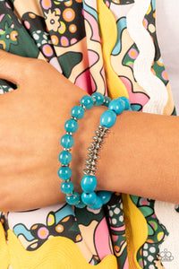 Infused with silver accents, rows of glassy and acrylic blue beads are threaded along stretchy bands around the wrist, resulting in a refreshing pop of color.