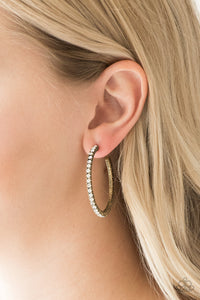 Encrusted in glassy white rhinestones, a textured brass hoop curls around the ear for a refined look. Earring attaches to a standard post fitting. Hoop measures 1 3/4" in diameter. Sold as one pair of hoop earrings.