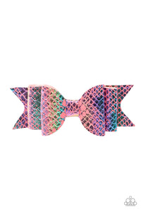 Featuring a rainbow scale pattern, an iridescent piece of leather delicately knots into a mermaid inspired bow. Features a standard hair clip.  Sold as one individual hair clip.