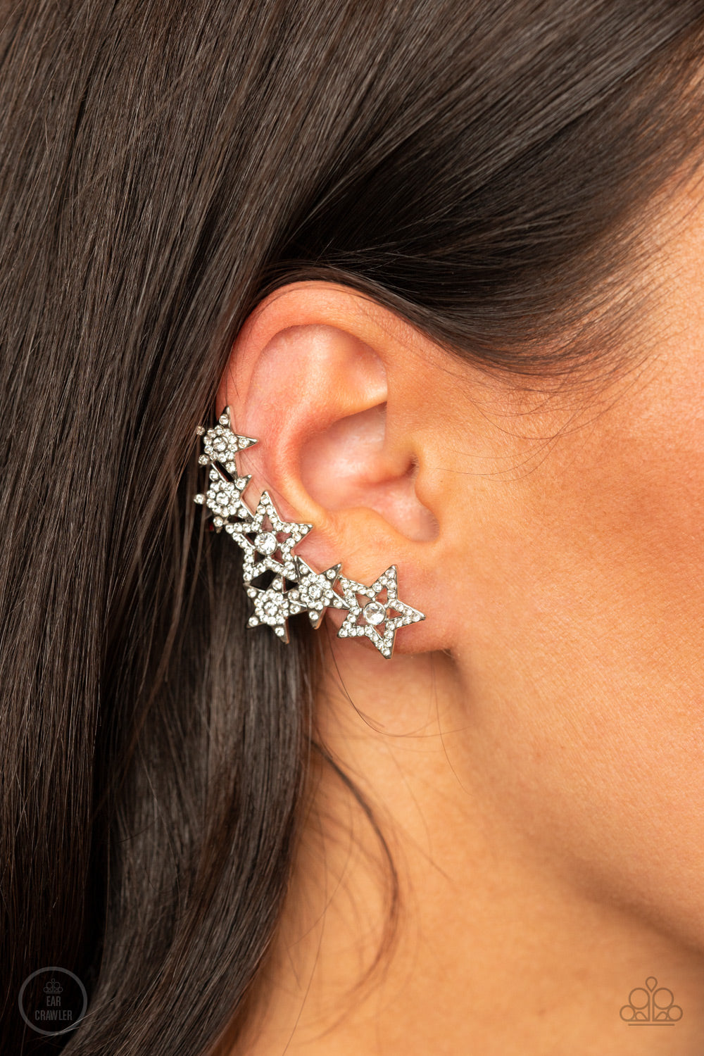 A stellar display of white rhinestone encrusted stars curve up the ear, coalescing into a sparkle-spangled statement piece. Earring attaches to a standard post fitting. Features a clip-on fitting on the back for a secure fit.  Sold as one pair of ear crawlers.