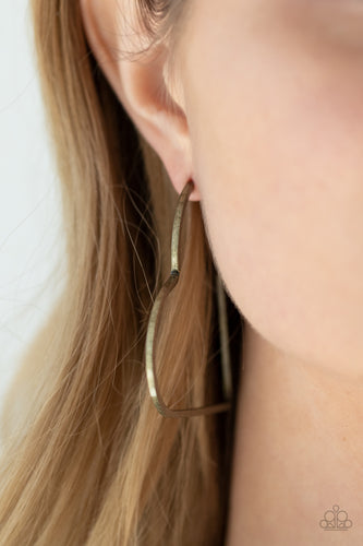 Brushed in a rustic antiqued finish, a flat brass bar delicately bends into an airy heart frame for a flirtatious finish. Earring attaches to a standard post fitting. Hoop measures approximately 2