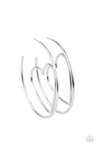 Shiny silver wire delicately bends into an airy heart frame inside a classic silver hoop, creating a flirtatious display. Earring attaches to a standard post fitting. Hoop measures approximately 2" in diameter.  Sold as one pair of hoop earrings.