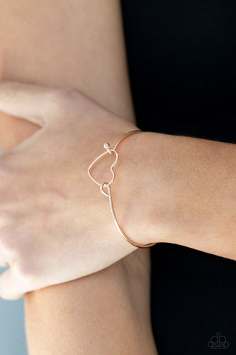 A dainty rose gold heart frame attaches to a dainty rose gold bangle-like cuff, creating a flirty centerpiece around the wrist. Features a toggle closure.  Sold as one individual bracelet.