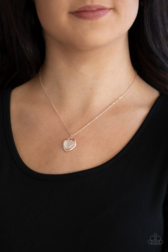 Featuring a dreamy cat's eye stone center, a glistening rose gold locket inspired frame glides along a dainty rose gold chain below the collar for a charming look. Sections of dainty white rhinestones dot the rose gold heart frame, adding flirty hints of shimmer. Features an adjustable clasp closure.  Sold as one individual necklace. Includes one pair of matching earrings.