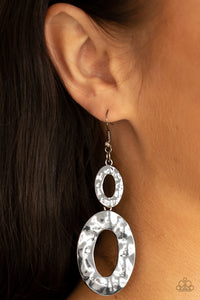 A mismatched pair of hammered gunmetal ovals delicately link into a blinding metallic lure. Earring attaches to a standard fishhook fitting.  Sold as one pair of earrings.