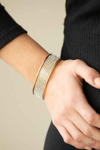 Row after row of white rhinestones are encrusted along the front of a thick gold cuff, creating a blinding statement piece around the wrist.  Sold as one individual bracelet.