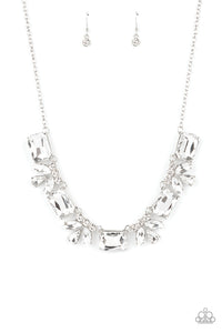 An oversized collection of white emerald cut gems and regally cut clusters of rhinestones delicately link below the collar, creating a dramatically sparkly fringe. Features an adjustable clasp closure.  Sold as one individual necklace. Includes one pair of matching earrings. 