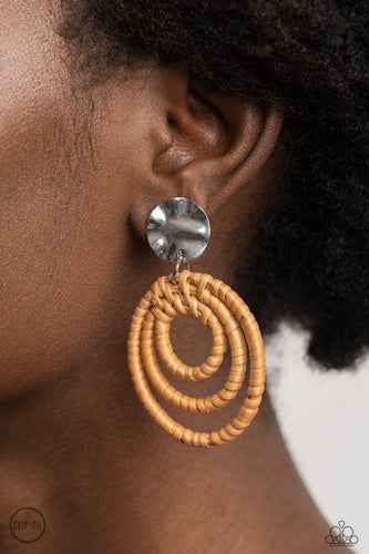 A hammered silver disc attaches to rippling hoops wrapped in wicker-like cording, creating an earthy lure. Earring attaches to a standard clip-on fitting.  Sold as one pair of clip-on earrings.