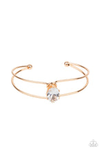 Load image into Gallery viewer, A dramatically oversized white rhinestone is fitted in place atop the center of a gold wire cuff, creating a jaw-dropping display around the wrist.  Sold as one individual bracelet.
