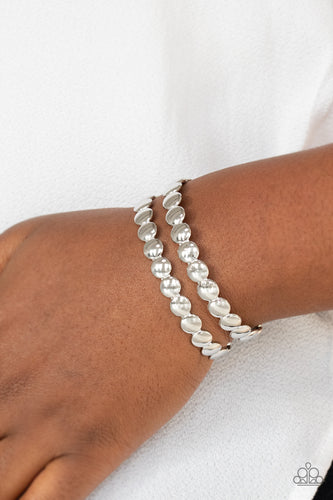 Brushed in a shiny finish, rows of flattened silver studs coalesce into a shimmery cuff around the wrist.  Sold as one individual bracelet.