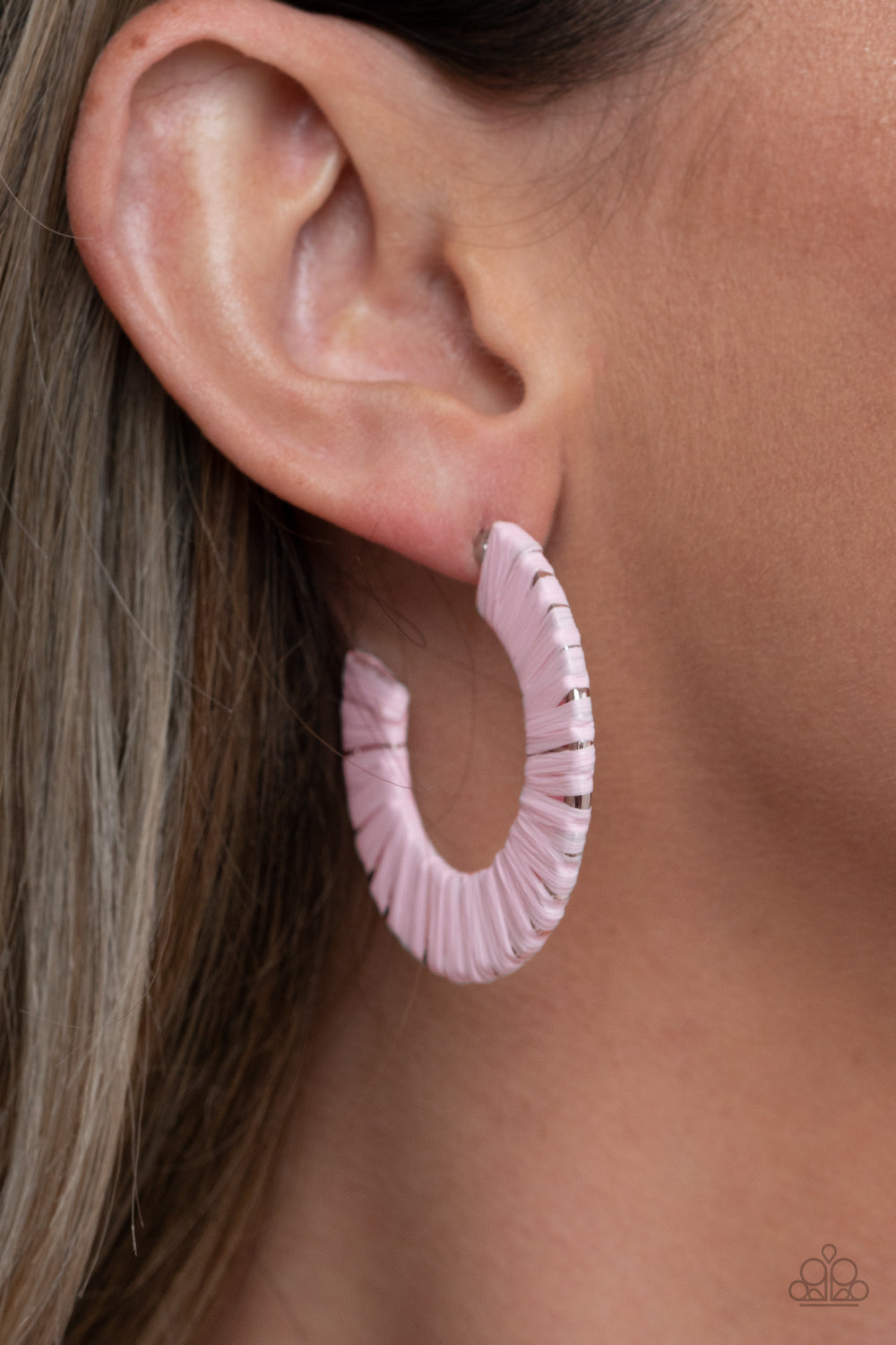 Pink wicker-like cording wraps around a thick silver hoop, creating a flirty pop of color. Earring attaches to a standard post fitting. Hoop measures approximately 1 1/2