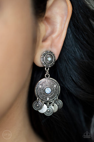 Dainty silver discs and antiqued floral frames dance from the bottom of an ornately embossed silver frame that links to a matching silver fitting. Both frames are dotted in blue opalescent rhinestone centers, while the largest of frames is sprinkled in dainty white rhinestone accents for a dreamy finish. Earring attaches to a standard clip-on fitting.  Sold as one pair of clip-on earrings.
