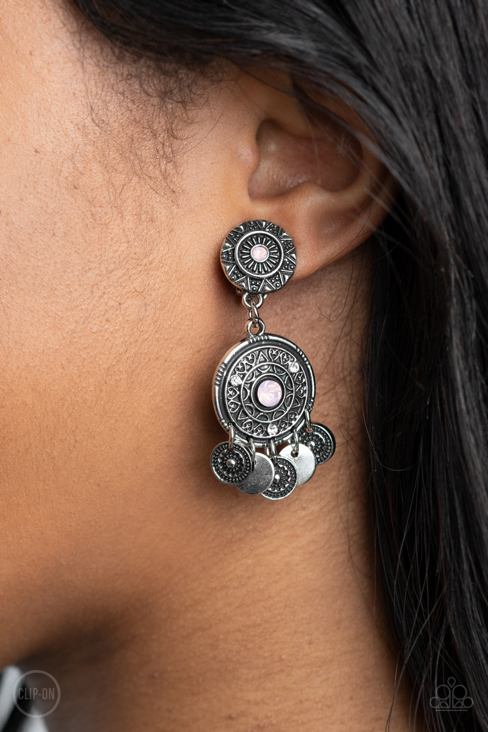 Dainty silver discs and antiqued floral frames dance from the bottom of an ornately embossed silver frame that links to a matching silver fitting. Both frames are dotted in pink opalescent rhinestone centers, while the largest of frames is sprinkled in dainty white rhinestone accents for a dreamy finish. Earring attaches to a standard clip-on fitting.  Sold as one pair of clip-on earrings.