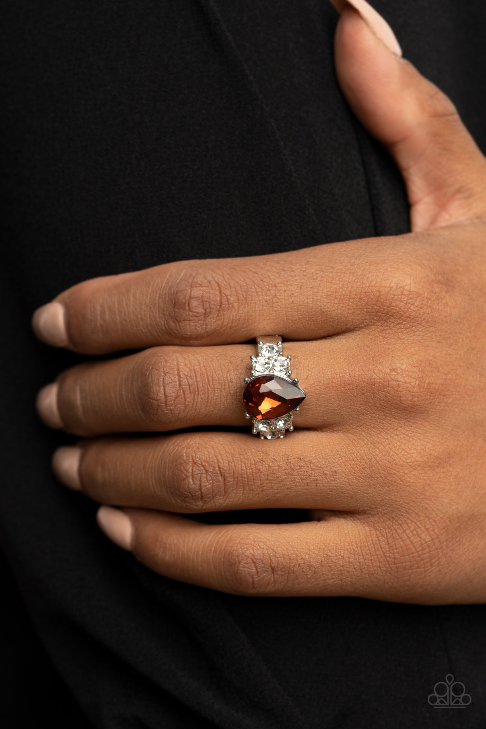 Trios of glassy white rhinestones flank an oversized teardrop topaz rhinestone, creating a sparkly centerpiece atop a dainty silver band. Features a dainty stretchy band for a flexible fit.  Sold as one individual ring.