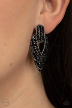 Load image into Gallery viewer, The front of a spade shaped silver frame is encrusted in row after row of glittery black rhinestones, creating a blinding buckle inspired statement piece. Earring attaches to a standard clip-on fitting.  Sold as one pair of clip-on earrings.

