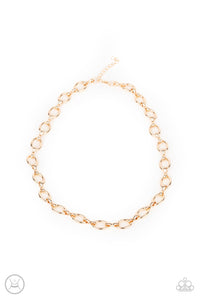 A collection of oversized gold ovals and glistening gold fittings interlock around the neck, creating an intense industrial look. Features an adjustable clasp closure.  Sold as one individual choker necklace. Includes one pair of matching earrings.   