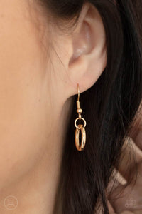 Gold oval link hanging from a gold fish hook earring.