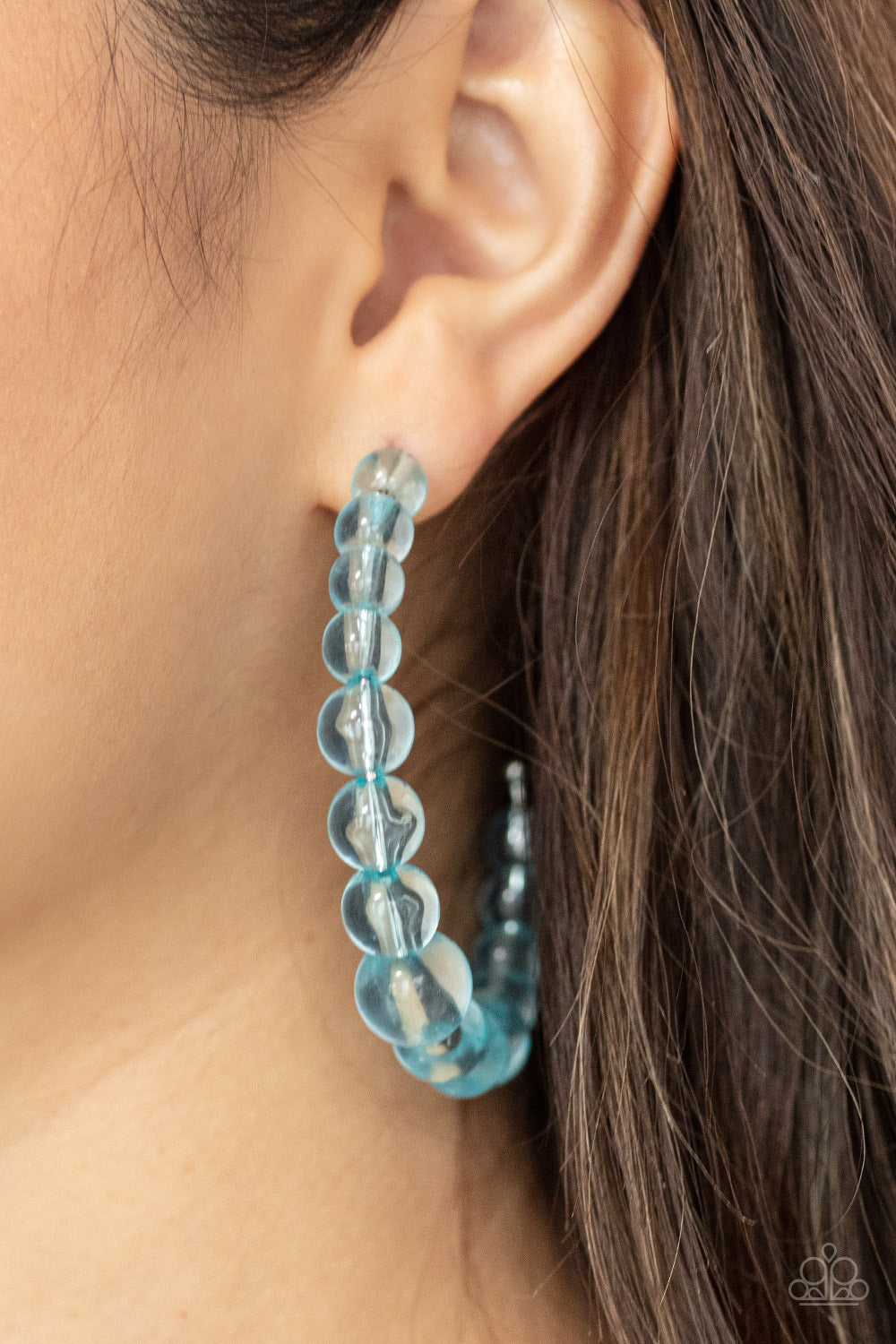 Gradually increasing in size at the center, a glassy collection of Cerulean beads are threaded along an oversized hoop for a bubbly effect. Earring attaches to a standard post fitting. Hoop measures approximately 2 1/2