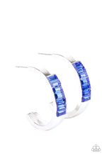 Load image into Gallery viewer, The front of a thick silver hoop is encrusted in glittery blue emerald cut rhinestones, creating a glamorous pop of color. Earring attaches to a standard post fitting. Hoop measures approximately 1&quot; in diameter.  Sold as one pair of hoop earrings.
