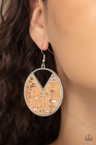 Featuring hints of white accents, an earthy piece of cork is placed into the center of a circular hoop. A triangular slice is removed from the cork, creating an edgy airy finish. Earring attaches to a standard fishhook fitting.  Sold as one pair of earrings.