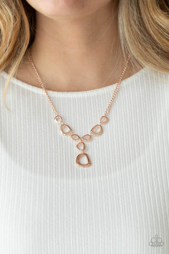 Irregular shaped rose gold rings connect to a rose gold chain as they make their way across the collar. Two rings dangle from the center for a stylish avant-garde fashion. Features an adjustable clasp closure. Includes one pair of matching earrings.