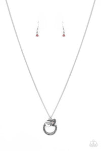 Dotted with a sparkly pink rhinestone, a dainty silver heart joins a silver ring stamped in the biblical passage, "Trust in the Lord with all thine heart," and a silver disc stamped in, "Proverbs 3:5," along the bottom of a lengthened silver chain, creating an inspirational pendant. Features an adjustable clasp closure.  Sold as one individual necklace. Includes one pair of matching earrings.