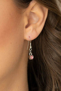 Pink rhinestone hanging from a silver fish hook earring.