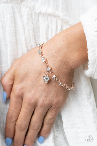 Brilliant white rhinestones in rose gold settings are linked together and accented with a charming white rhinestone heart that dangles sweetly from the wrist. Features an adjustable clasp closure.  Sold as one individual bracelet.