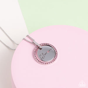 Infused with a silver ring of glassy pink rhinestones, a glistening silver disc is dotted with dainty pink rhinestone and stamped in the word, "Glamma," as it swings below the collar for a glamorously sentimental look. Features an adjustable clasp closure.  Sold as one individual necklace. Includes one pair of matching earrings.