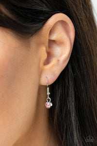 Pink rhinestone hanging from a silver fish hook earring.