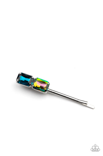 Featuring elegant emerald style cuts, an oversized pair of blue and oil spill rhinestones adorn the end of a classic silver bobby pin.  Sold as one individual bobby pin.